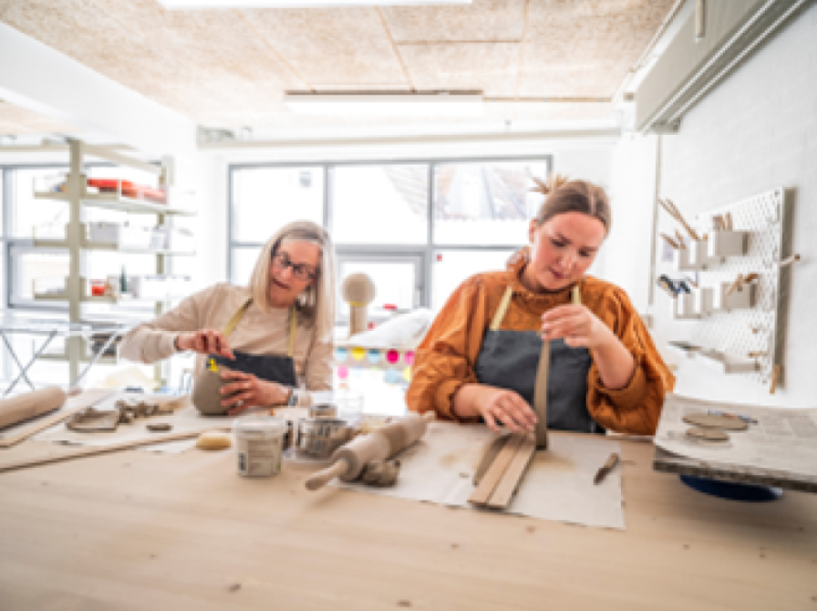 To personer arbejder med ler